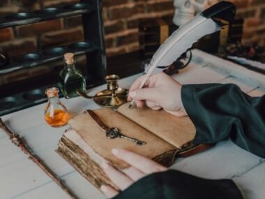 Historical quill pen writing on an aged notebook, surrounded by antique ink bottles, a vintage key, and candles, reflecting the timeless elegance and cultural significance of quills in writing history.